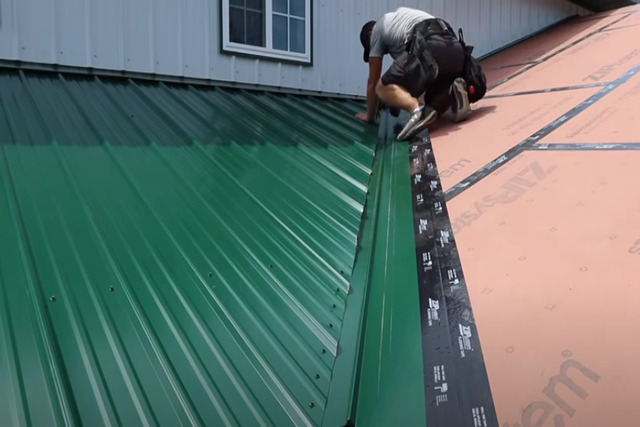 Roof worker building a metal valley