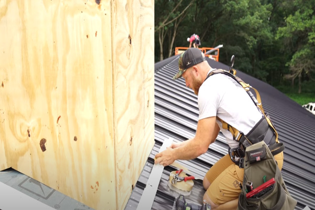 Roofing worker building a standing seam ridge