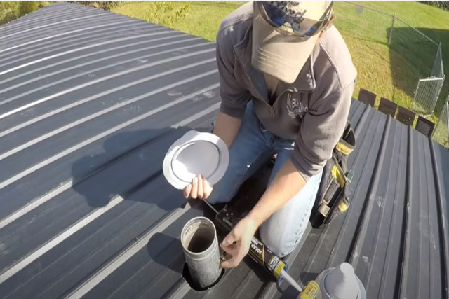 Roofing worker installing a metal roof